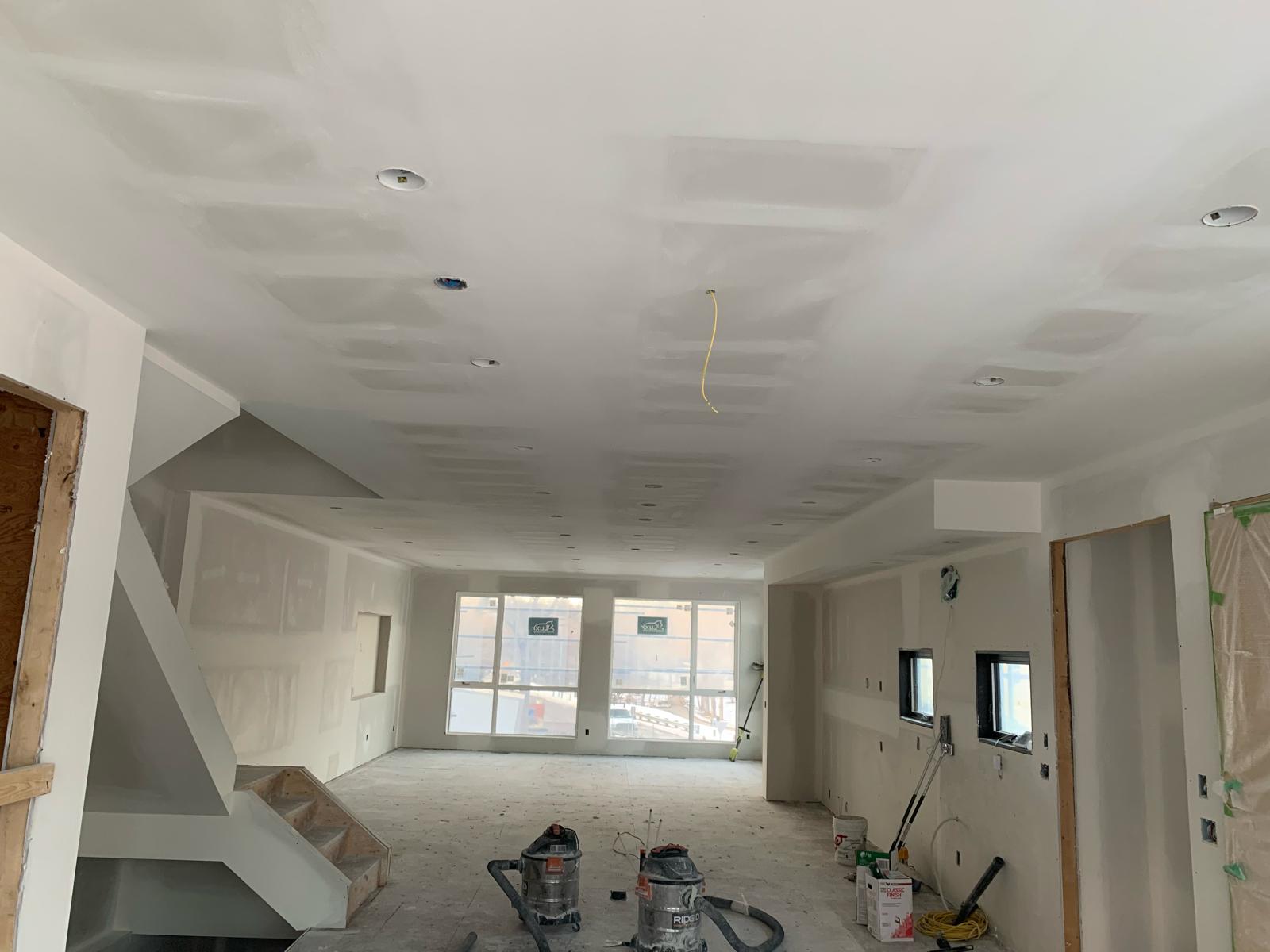 Flat drywall ceiling taped and mudded with recessed lighting in a Calgary home by Shyam Drywall