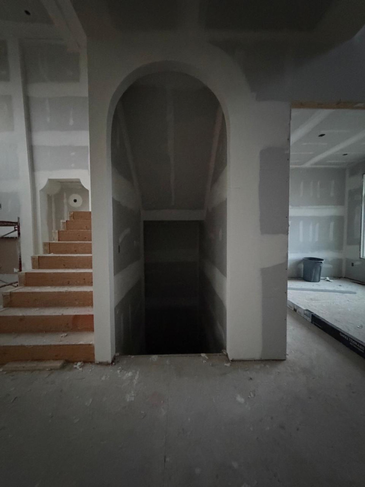 Arched drywall opening beside a staircase in a Calgary home