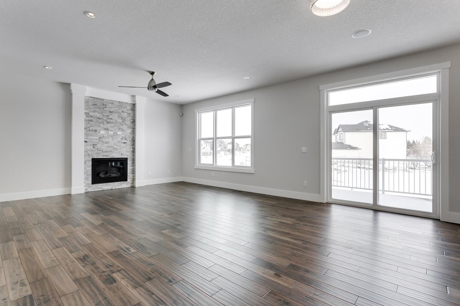 Finished living room with painted drywall walls and stone fireplace in a Calgary home