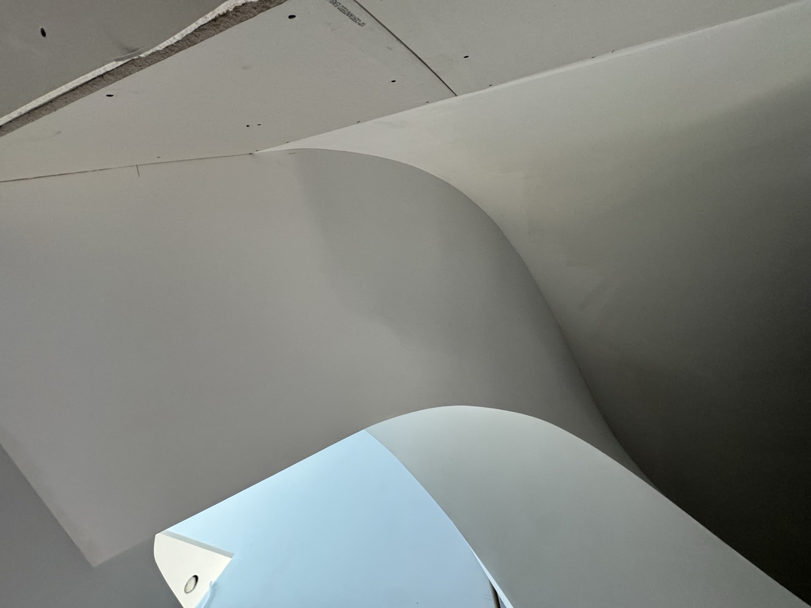 Smooth curved drywall stairwell wall by Shyam Drywall